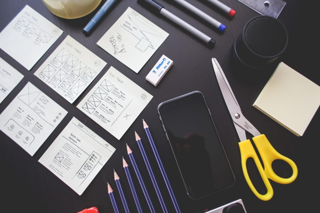 Una mesa con un teléfono, tijeras, lápices y post-it.